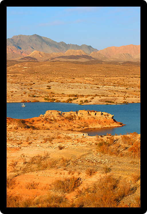 Evening sunlight creates striking colors on the rocky shoreline of Lake Mead in Nevada.