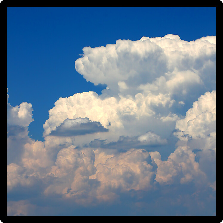 Giant cumulonimbus thunderstorm clouds erupt into the sky on a hot summer day.