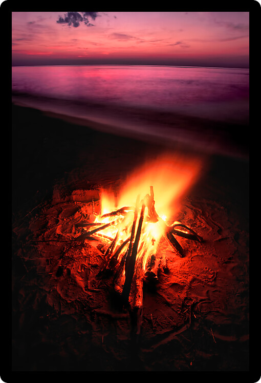 Blazing campfire at sunset along the beautiful beach of Lake Superior in northern Michigan.