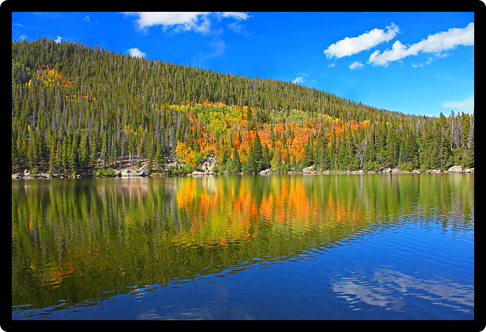 Autumn colors reflect off Bear Lake in Rocky Mountain National Park Colorado.