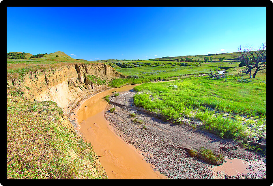 Calm waters flow through Sage Creek in Badlands National Park of South Dakota.
