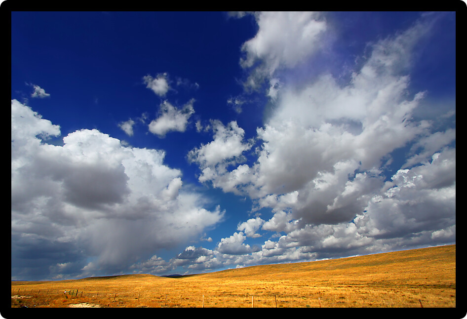 Rolling hills of the Wyoming countryside illuminated under brilliant sunshine.