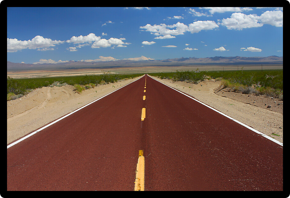 Long road runs through the vast openness of the Mojave National Preserve in California.