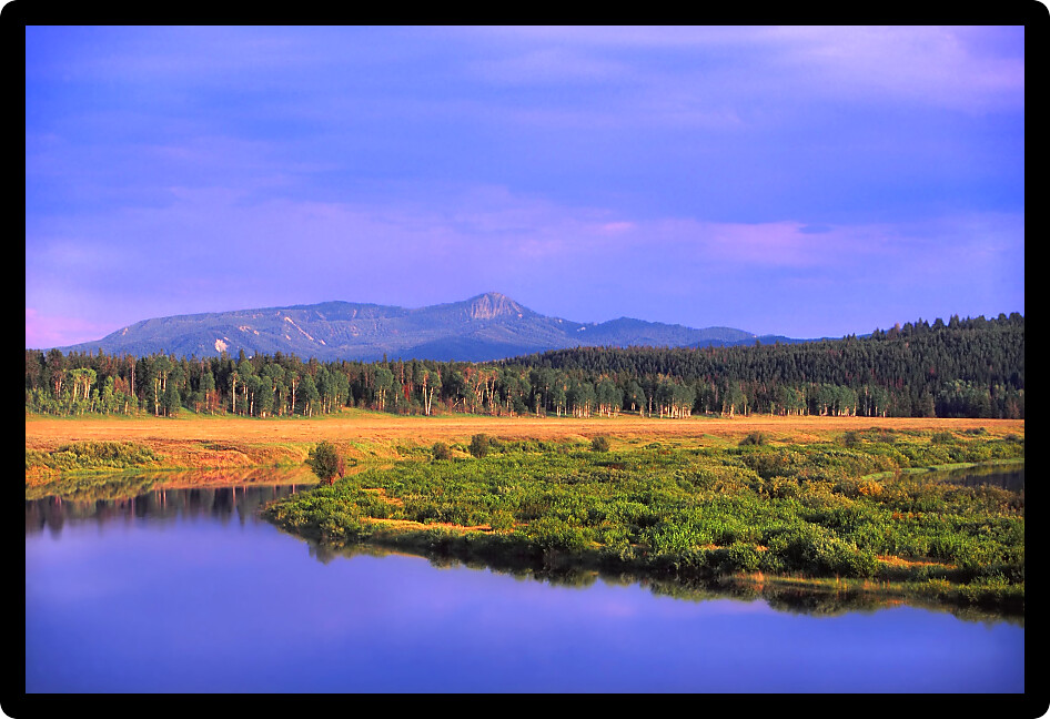 Evening light paints a calm scene at Oxbow Bend on Snake River Grand Teton National Park.