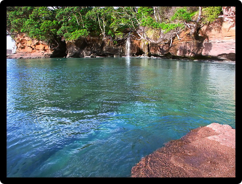 Waterfall flows into the ocean at Goat Island Marine Reserve on the North Island of New Zealand.