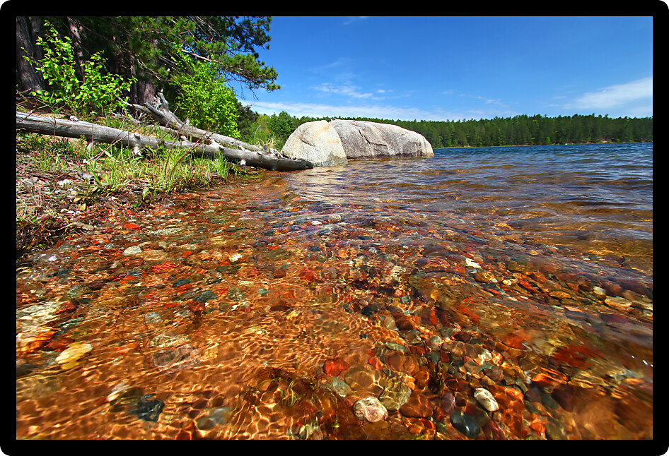 Beautifully colored rocks shine through clear waters in a northwoods Wisconsin Lake.