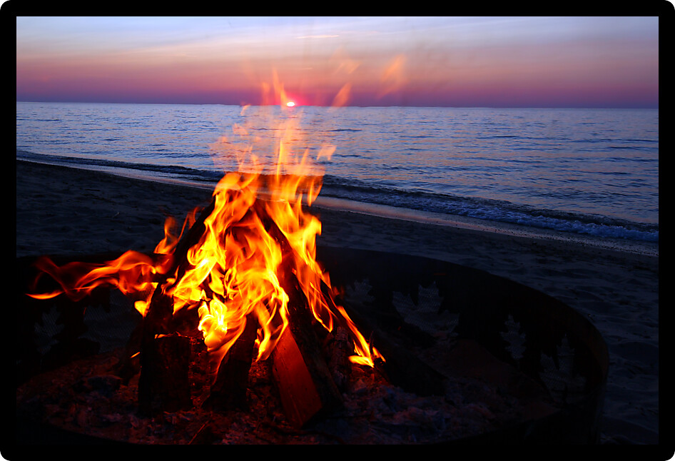 Blazing campfire at sunset along the beautiful beach of Lake Superior in northern Michigan.