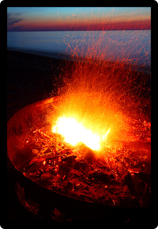 Blazing campfire at sunset along the beautiful beach of Lake Superior in northern Michigan.