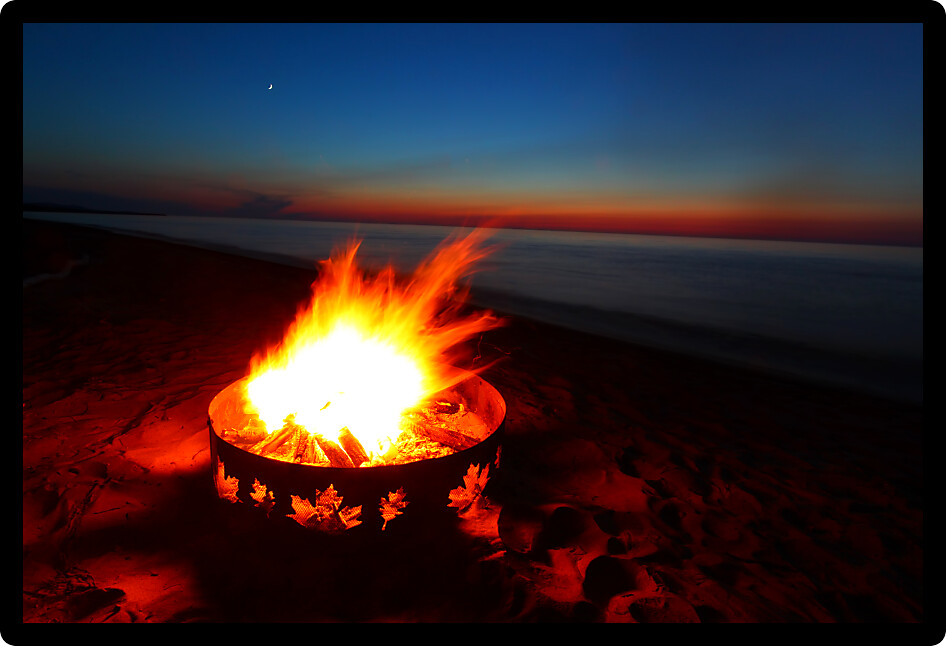 Campfire and beautiful sunset along the beautiful beach of Lake Superior in northern Michigan.