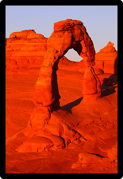 Evening sunlight illuminates Delicate Arch in Arches National Park Utah.