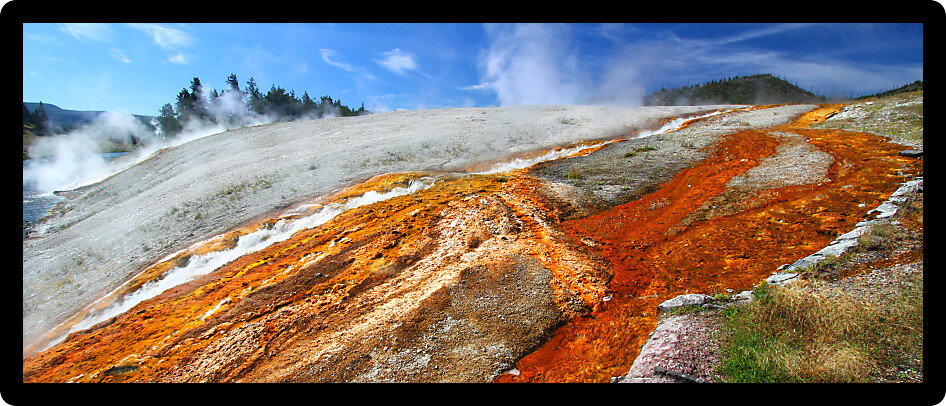 Hot water from the Midway Geyser Basin cascades into the Firehole River in Yellowstone National Park Wyoming.