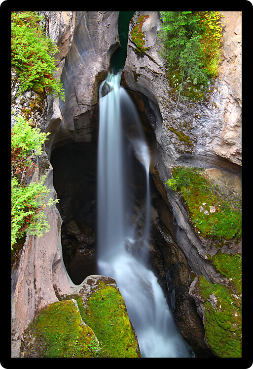 Smooth waterfall flows through Maligne Canyon of Jasper National Park in Canada.