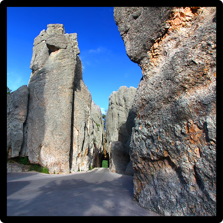 Narrow one lane tunnel through solid rock along the scenic Needles Highway of South Dakota.