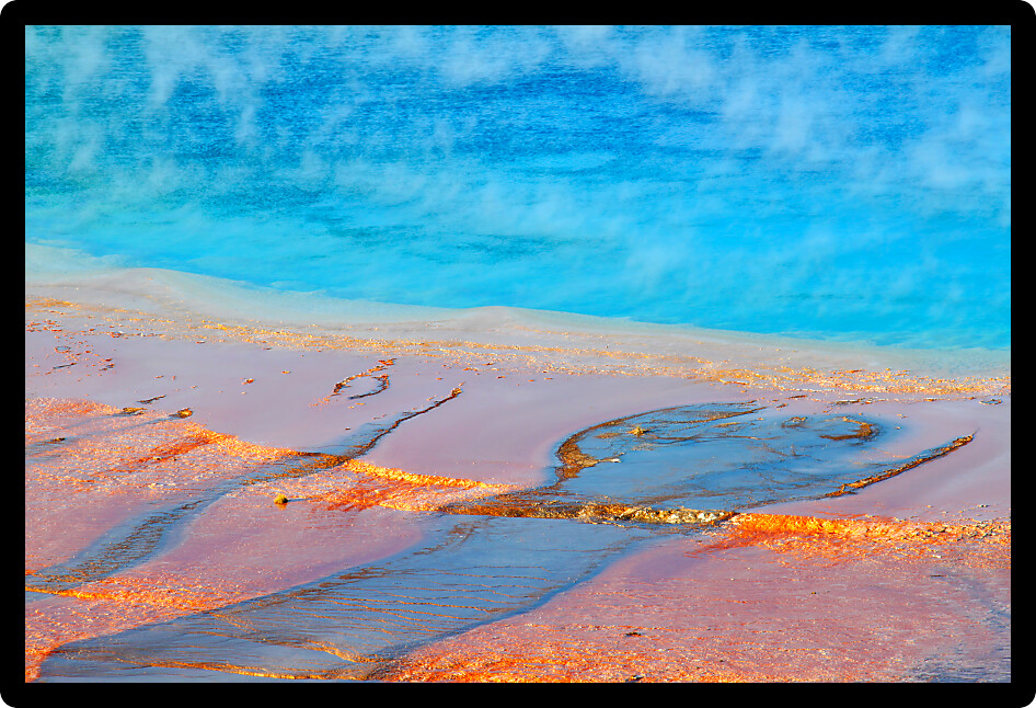 Steam rises off the amazing colors of Grand Prismatic Spring in Yellowstone National Park USA.