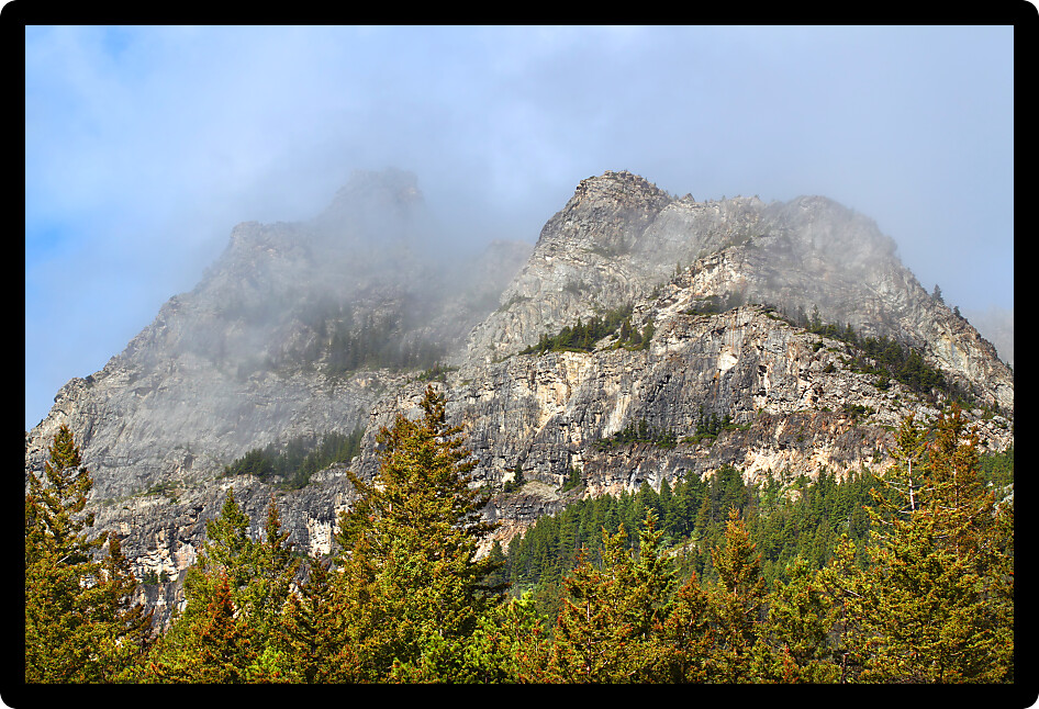 Low clouds hang over the forest adorning Mount Crandell in Waterton Lakes National Park of Canada.