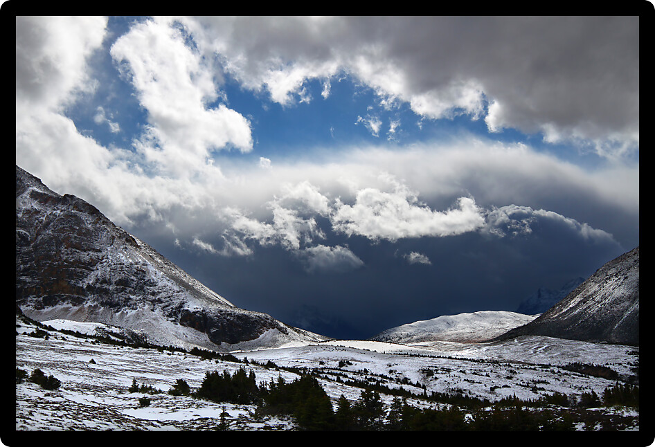 Sunlight shines through dark storm clouds near Mount Edith Cavell of Jasper National Park in Canada.
