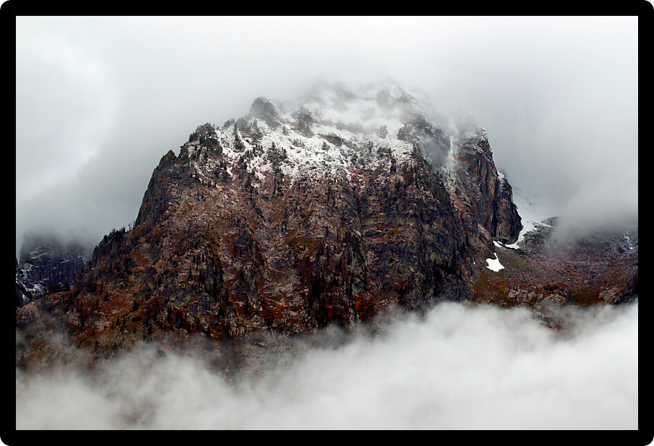 Dense clouds obscure jagged peaks of the Teton Range in western Wyoming