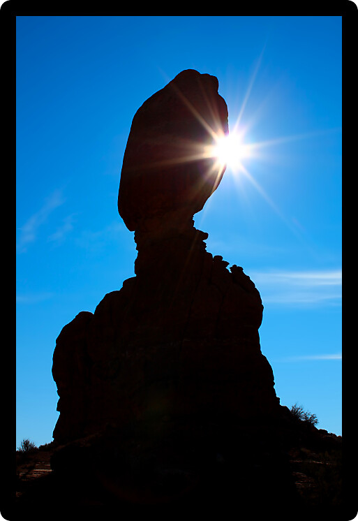 Sunlight shines from behind Balanced Rock at Arches National Park in Utah.
