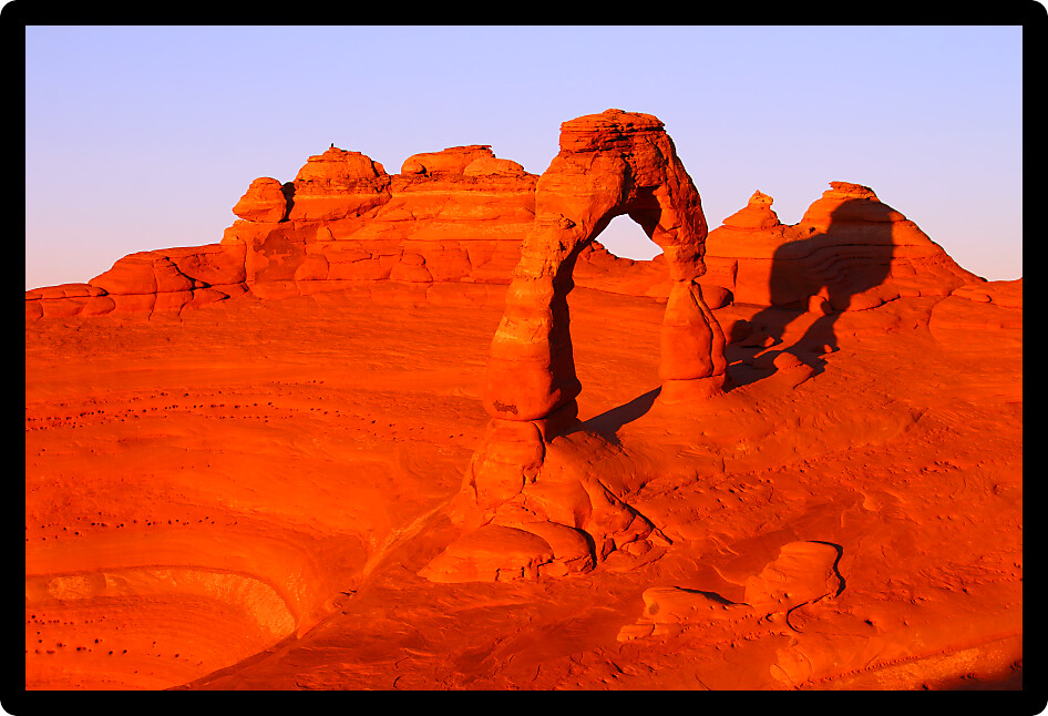 Evening sunlight illuminates Delicate Arch in Arches National Park Utah.