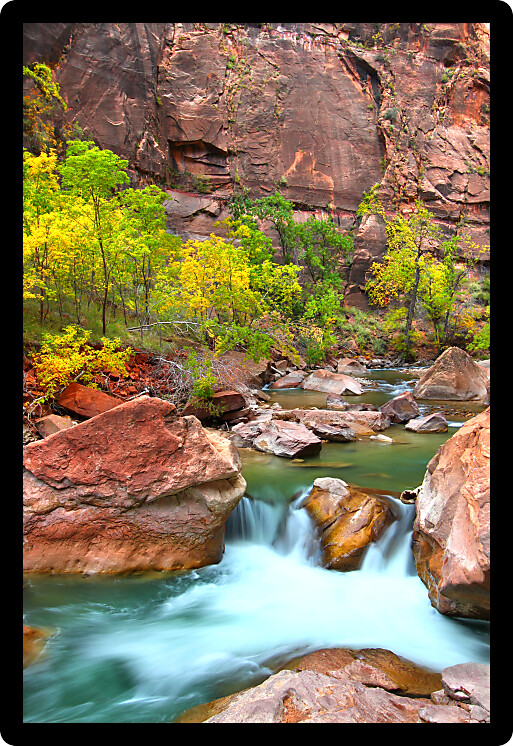 Small Virgin River waterfall through large boulders in Zion Canyon of Utah.